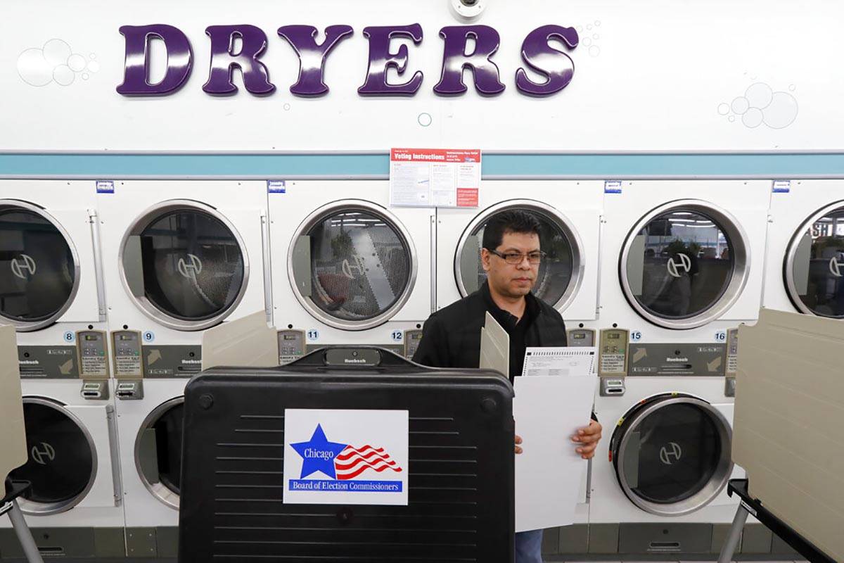 Guillermo Cruz-Sanchez takes his ballot to the ballot box at the Su Nueva Lavanderia polling pl ...