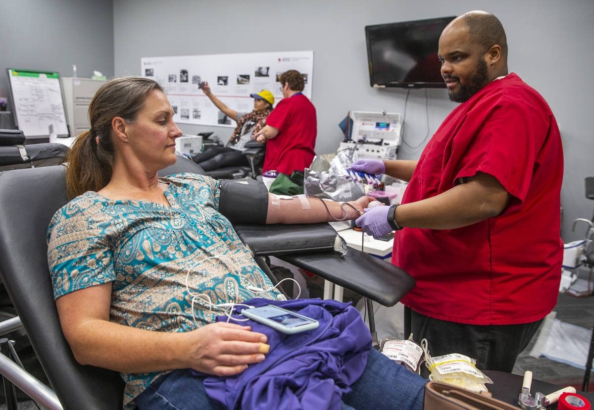 Blood donor Jennaya Fernane, left, has her blood taken by Red Cross team leader Darryl Thompson ...