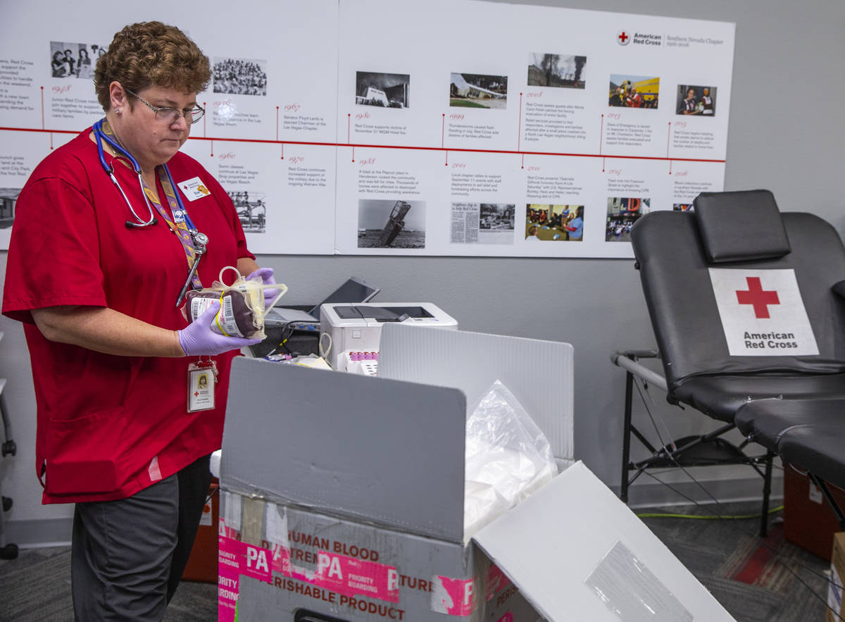 Red Cross team leader Eva Klappa packs new blood donations into a box with ice at the American ...
