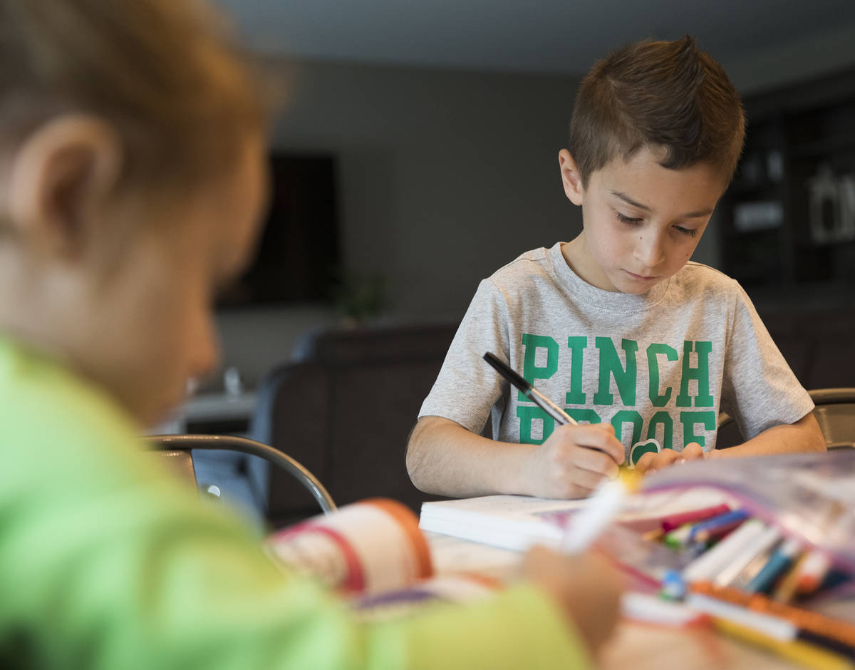 Alex Doleshal, 6, works on a workbook with his sister, Angie, 3, at their home in Henderson, Tu ...