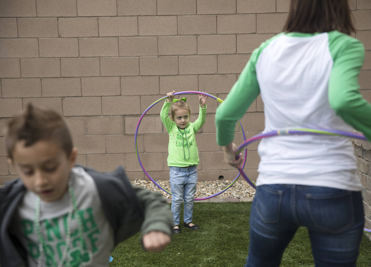 Angie Doleshal, 3, center, plays out sider with her brother, Alex, 6, left, and her mother Mari ...