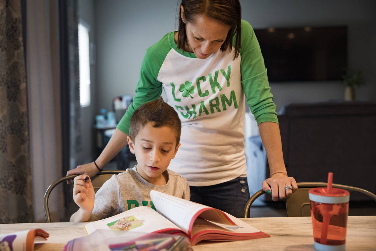 Alex Doleshal, 6, practices reading in a workbook with his mom Maria Doleshal at their home in ...
