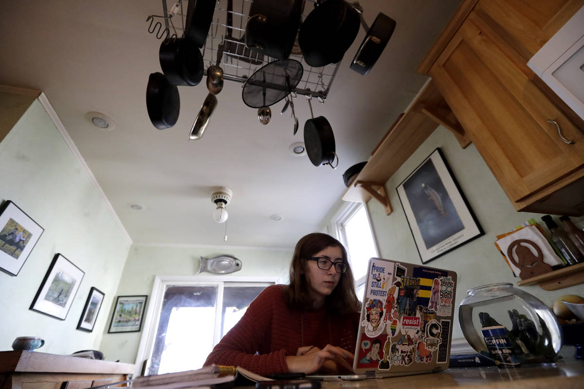 Olivia Marton, an 11th grader at Lincoln Park High School, studies school work with her compute ...