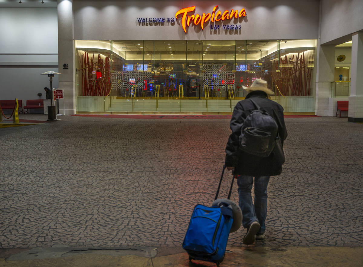 A lone traveler walks toward the entrance to the Tropicana as nonessential business closures co ...