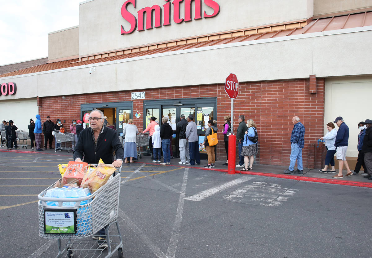 Jim Nazemi, 81, pushes his shopping cart after shopping as other seniors line up at a Smith's s ...