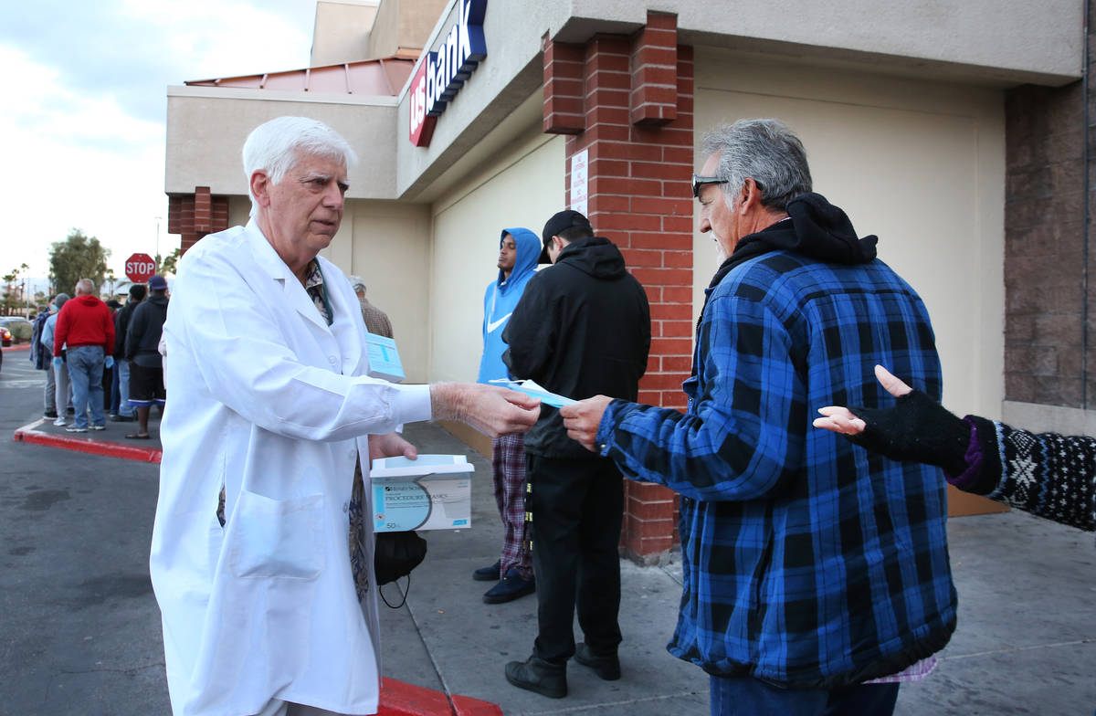 Dr. Mike Moore handouts face mask to seniors who lined up outside a Smith's store on Maryland P ...