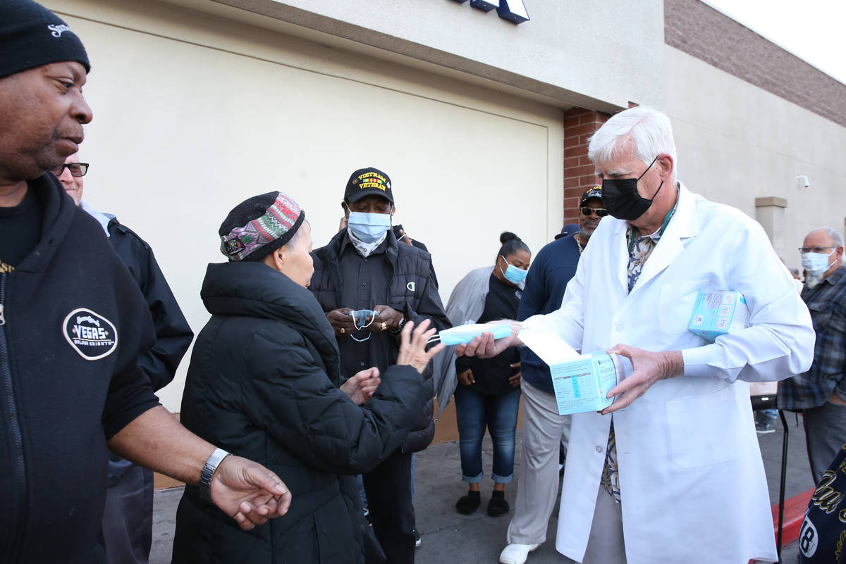 Dr. Mike Moore handouts face mask to seniors who lined up outside a Smith's store on Maryland P ...