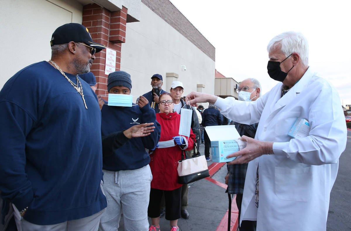 Dr. Mike Moore handouts face mask to seniors who lined up outside a Smith's store on Maryland P ...