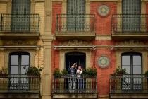 A young boy plays his trumpet from a balcony, in Pamplona, northern Spain, Wednesday, March 18, ...