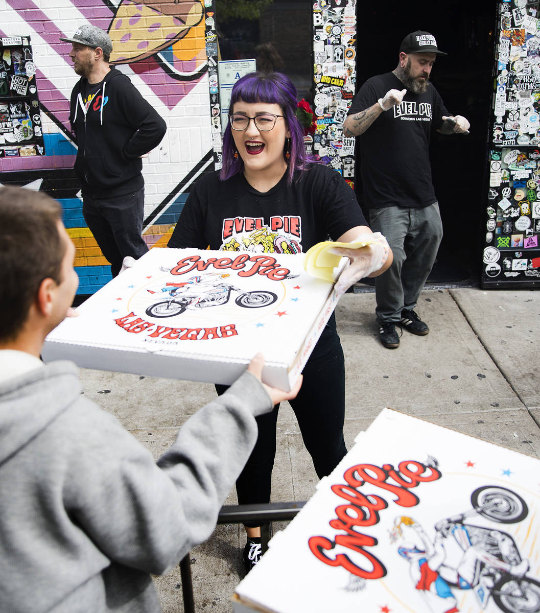 Employee Aly Bosnos hands out a pizza at Evel Pie in Las Vegas, Wednesday, March 18, 2020. Evel ...