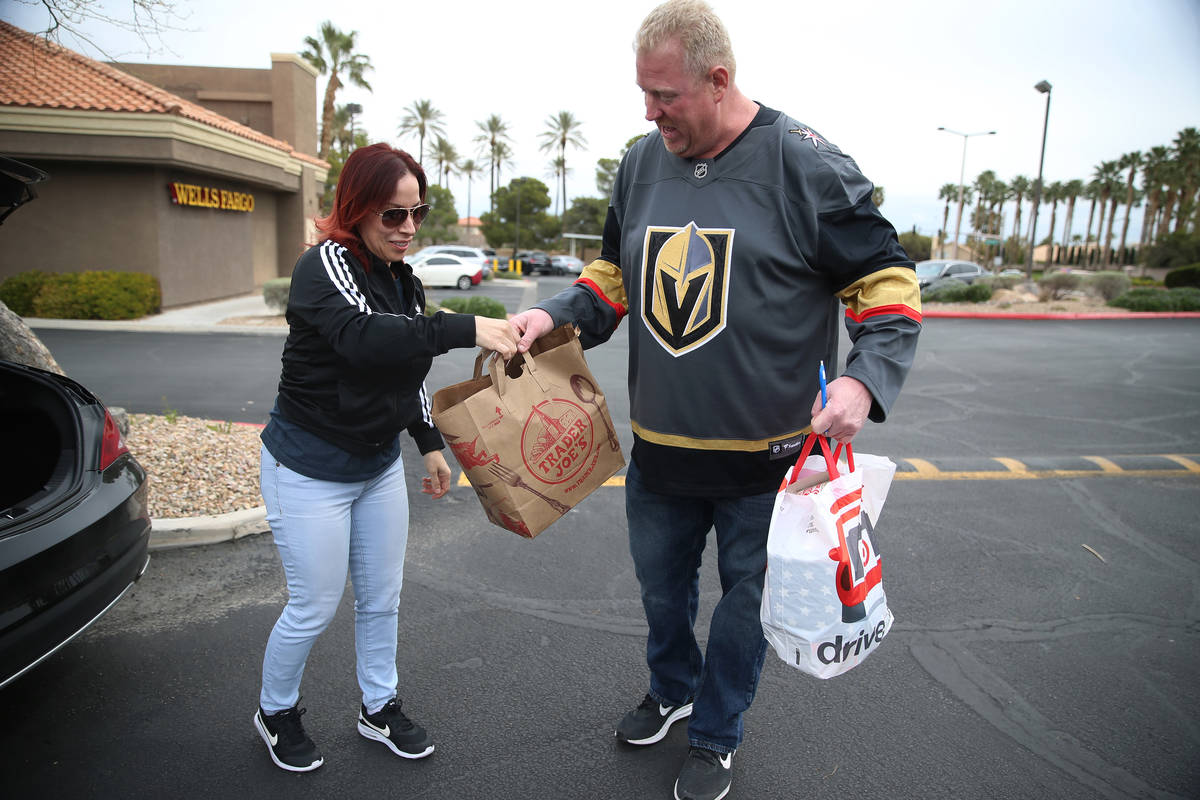 Brenda Karcz, left, makes a donation to Matty Evans who was collecting paper goods, cleaning su ...