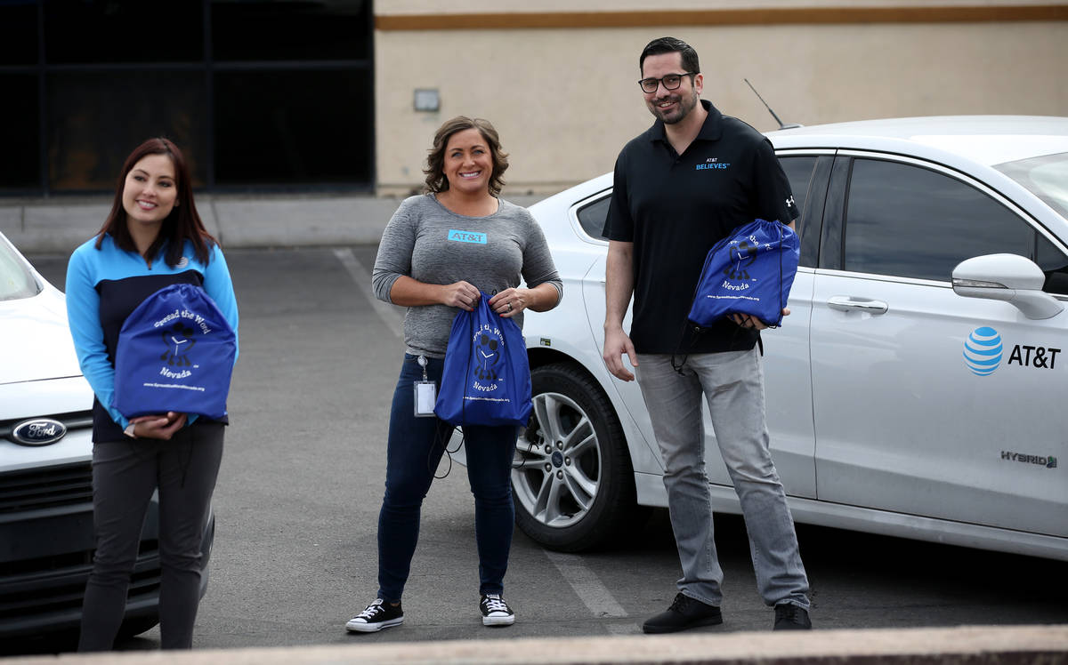 AT&T employees, from left, Jeanette Rupert, Rhiannon Leonard and Omar Saucedo deliver kits with ...