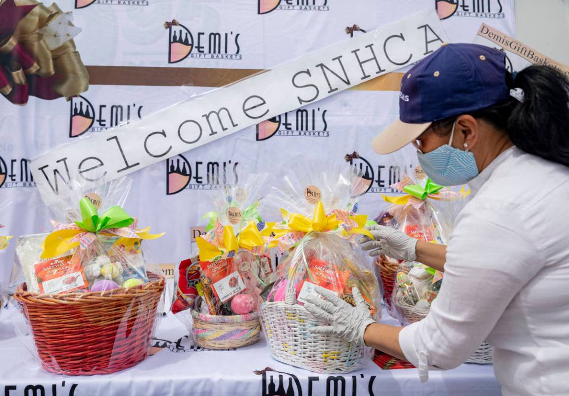 Demi Hou, owner and operator of Demi's Gift Baskets, adds grocery store gift cards to the baske ...