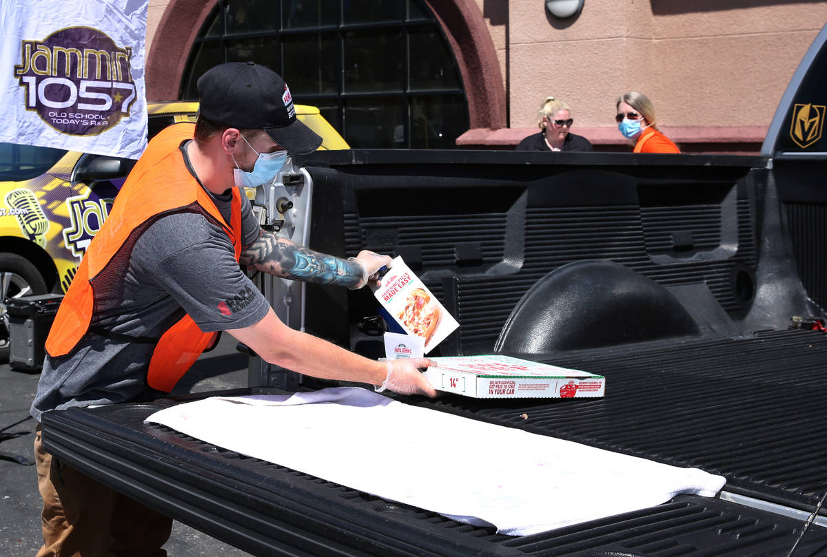 Mathew Christman, manager at Papa Jone's Pizza, places a box of pizza and a soft drink on a cli ...