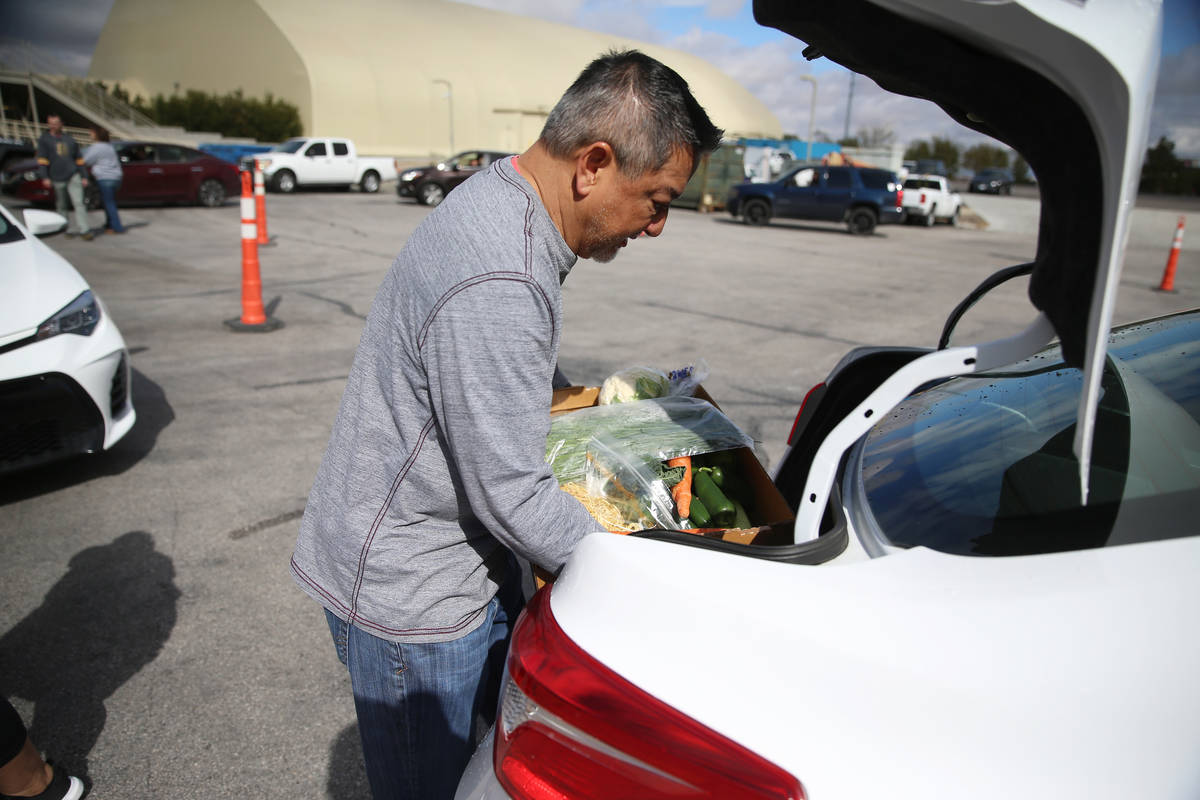 Executive director of player services Luke McEwin delivers food to a team member's car at the M ...