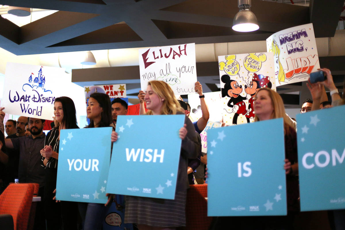 UFC employees hold up signs of wishes for children at an event by Make-A-Wish in partnership wi ...
