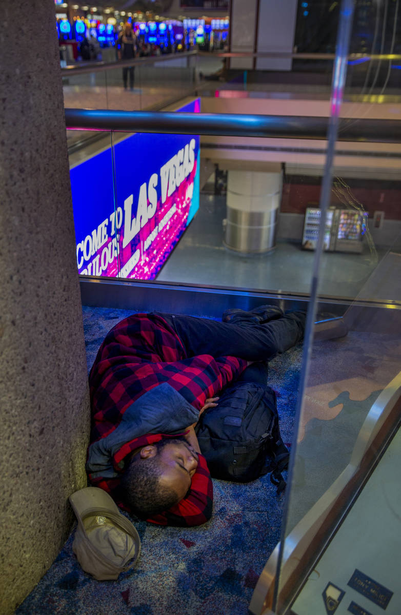 A passenger naps in a corner within Terminal 1 at McCarran International Airport, now less crow ...