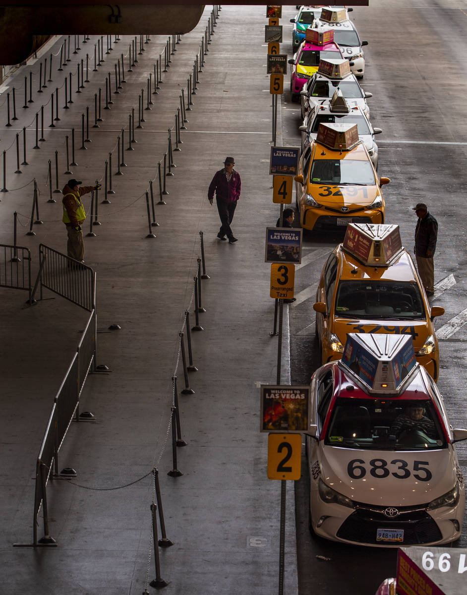 Taxis line up into Terminal 1 at McCarran International Airport with less fares being taken due ...