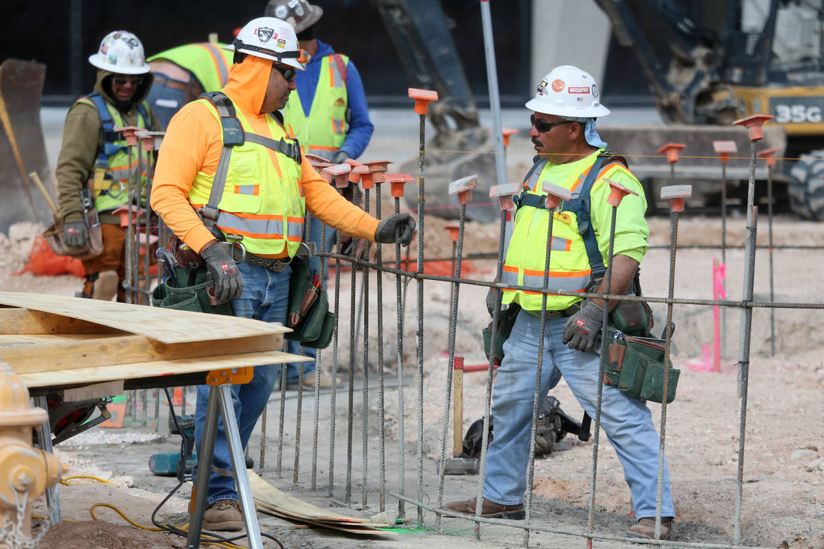 Workers speak to each other at the Raiders Allegiant Stadium construction site in Las Vegas, We ...