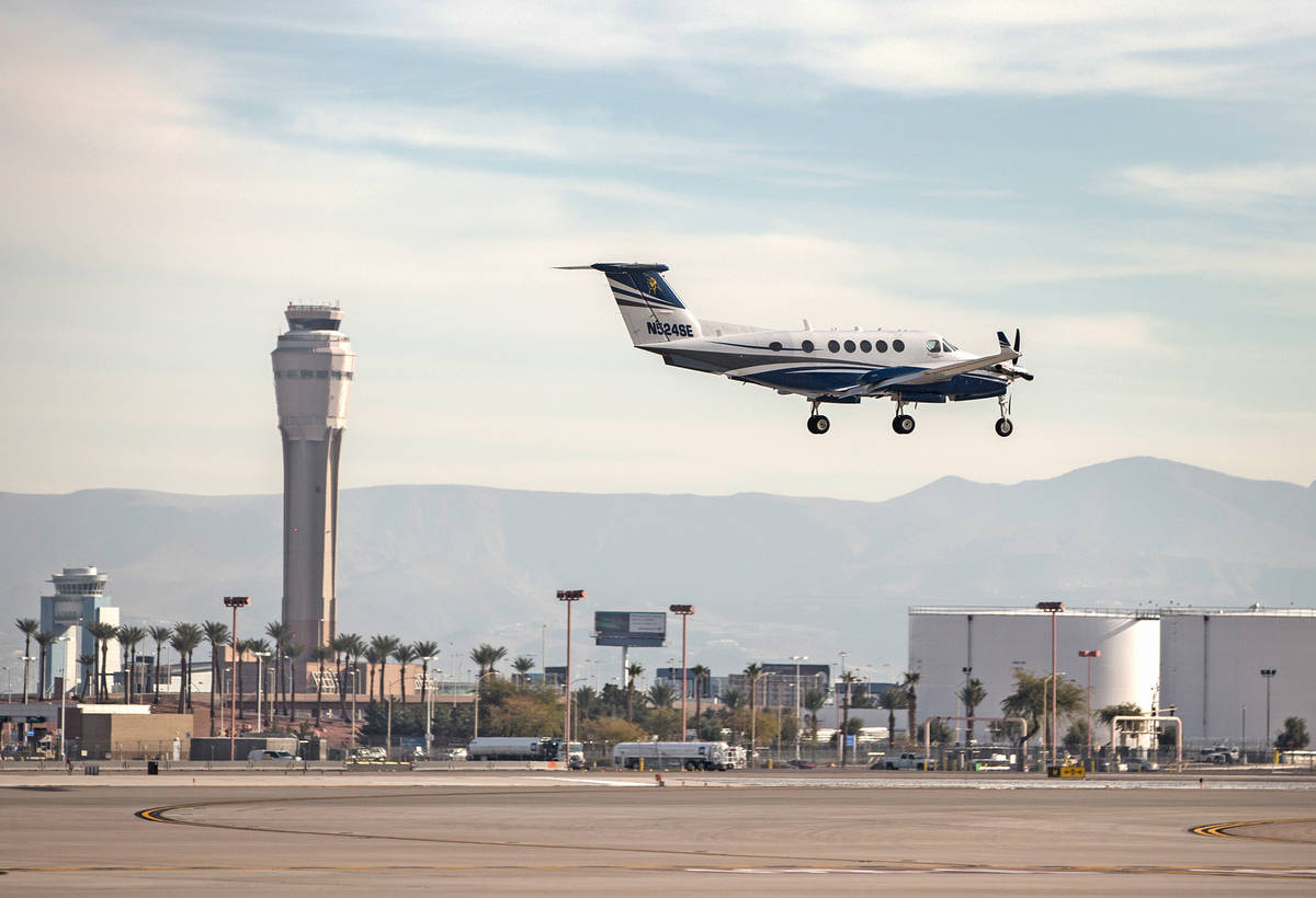 A plane passes by the air traffic control tower as it prepares to land at McCarran Internationa ...