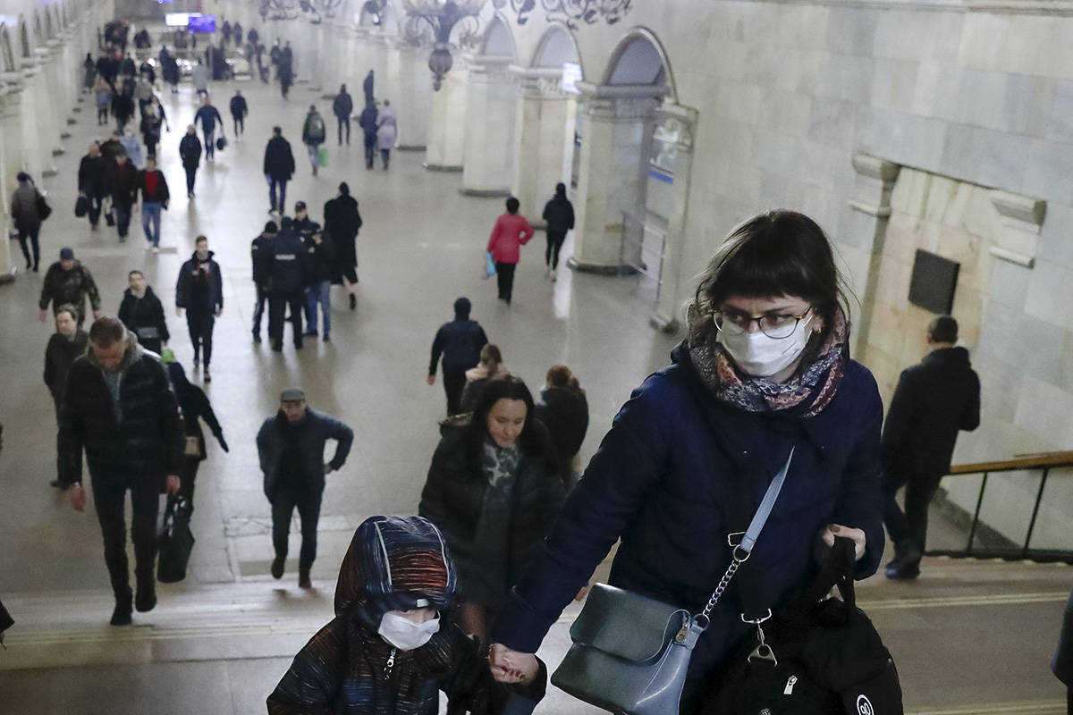 A woman with her child wear medical masks walk inside the Komsomolskaya Metro (subway) station ...