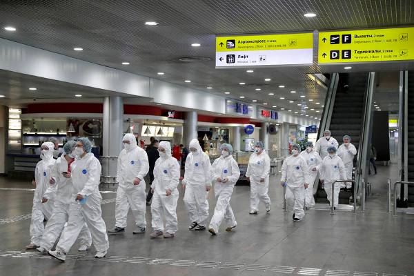 Russian medical experts walk to start their shift to check passengers arriving from foreign cou ...