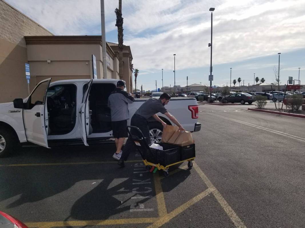 Smith's employee Jagger delivers a pickup order Thursday, March 19, 2020, in Henderson. (Heidi ...