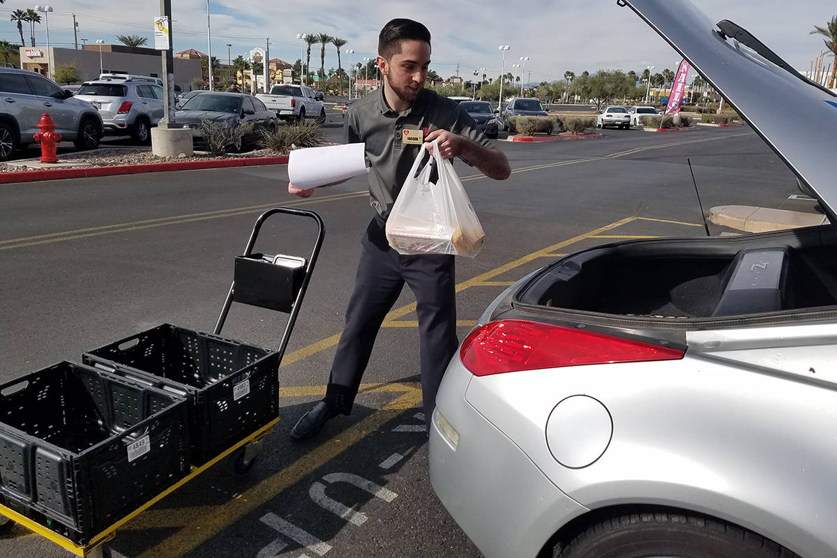 Smith's employee Jagger delivers a pickup order Thursday, March 19, 2020, in Henderson. (Heidi ...