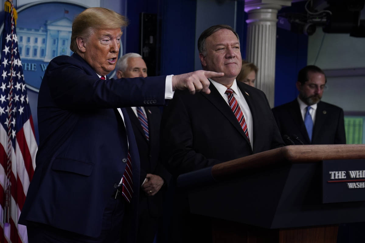 Secretary of State Mike Pompeo listens as President Donald Trump speaks during a coronavirus ta ...