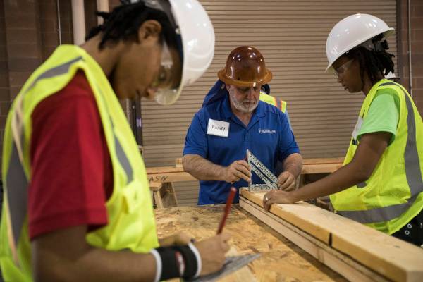 Randy Griebel, center, helps students and sisters Tamira Williams, left, and Alex Coulter, righ ...