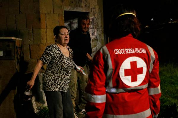 Red Cross volunteers bring food and disinfectants to homeless at Verano cemetery in Rome Saturd ...