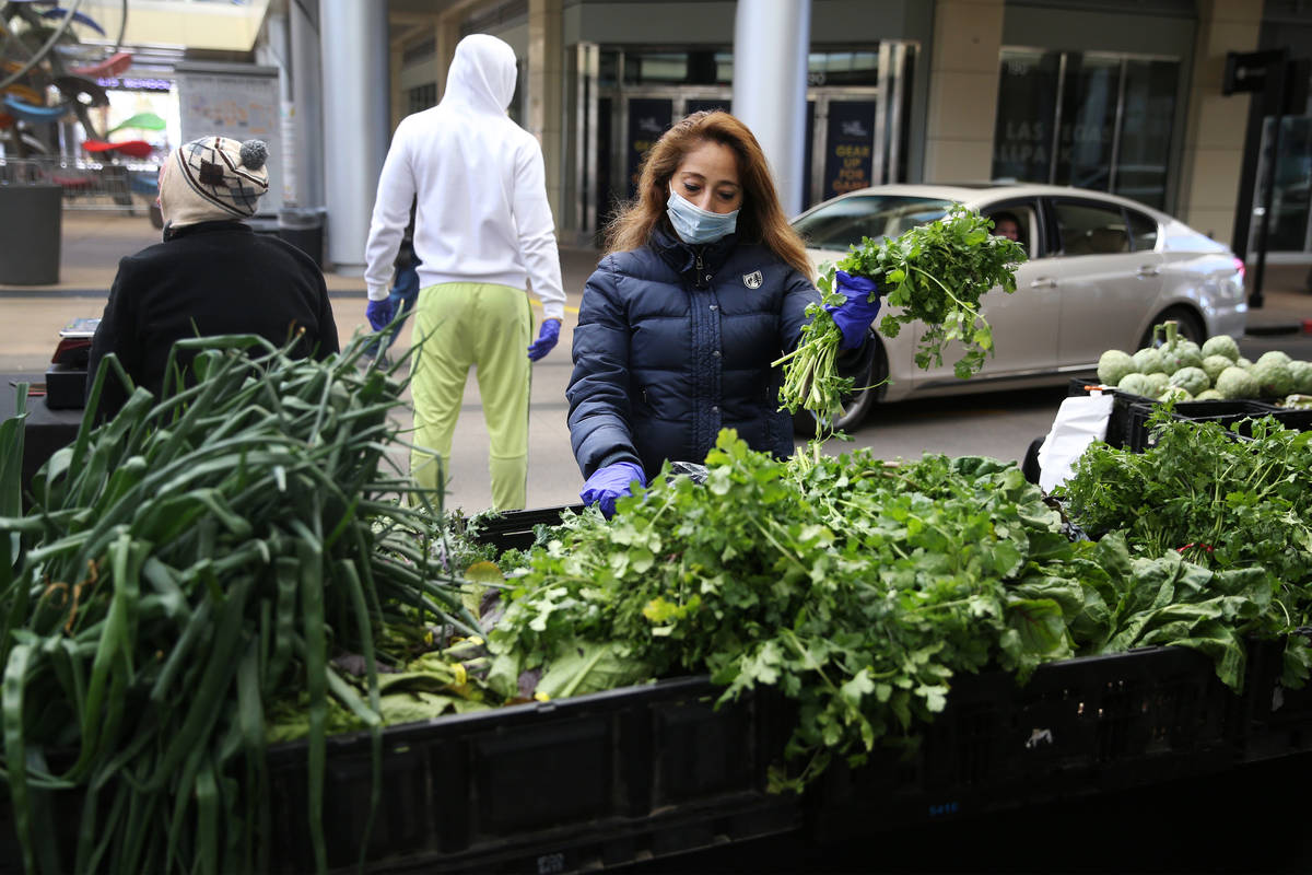 Mane Vega prepares herbs for customers at the Las Vegas Farmers Market in Downtown Summerlin in ...