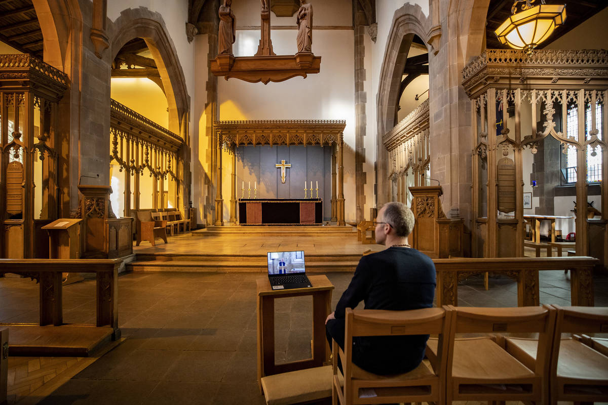 A church parishioner watches a laptop inside Liverpool Parish Church (Our Lady and St Nicholas) ...