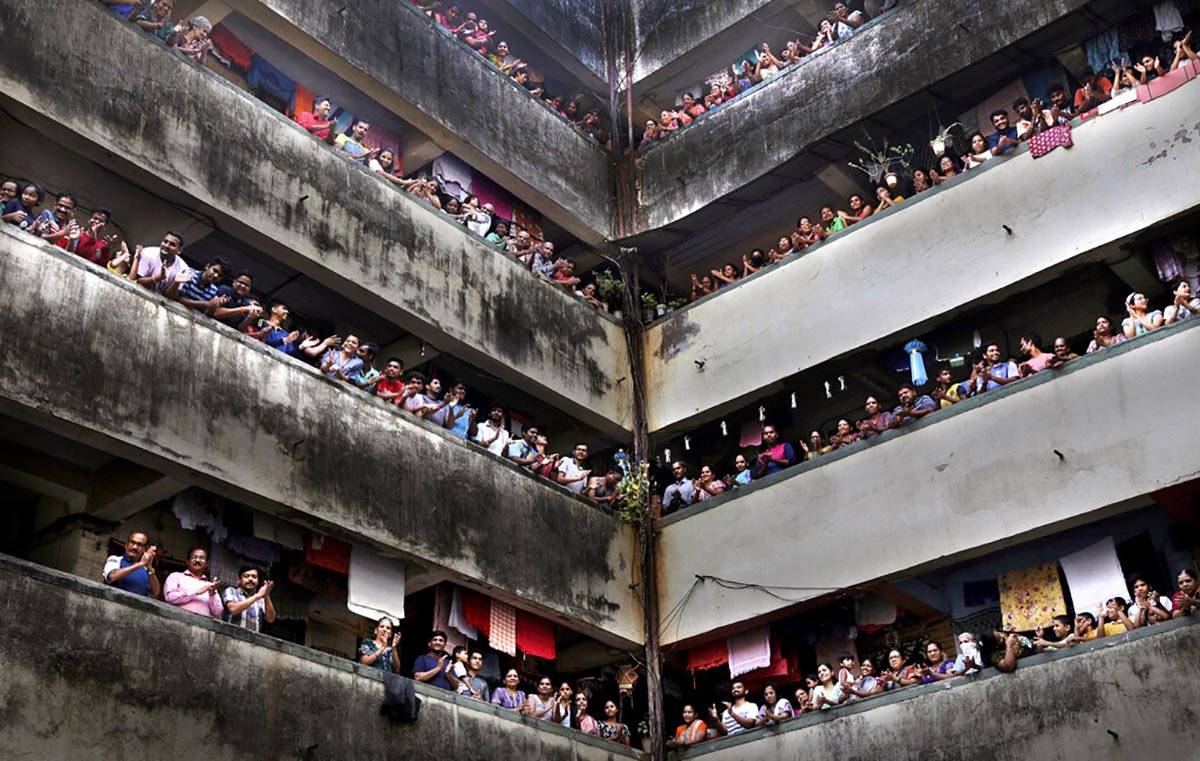 People clap from balconies in show of appreciation to health care workers at a Chawl in Mumbai, ...