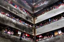 People clap from balconies in show of appreciation to health care workers at a Chawl in Mumbai, ...