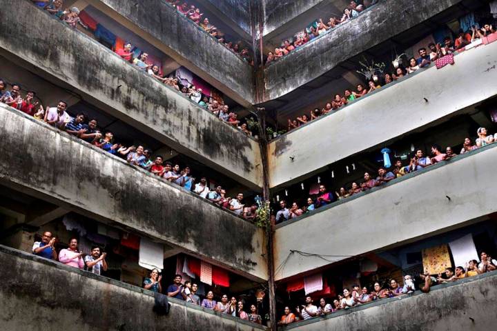 People clap from balconies in show of appreciation to health care workers at a Chawl in Mumbai, ...