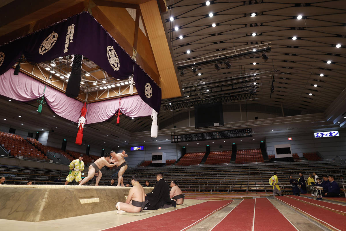 Sumo wrestlers fight on the ring as spectators' seats are empty during the Spring Grand Sumo To ...