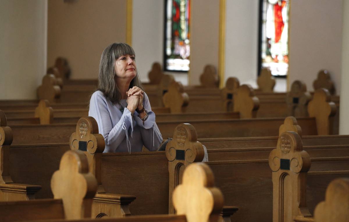 Due to the coronavirus, a parishioner prays during a modest and shortened service at St. Mary's ...