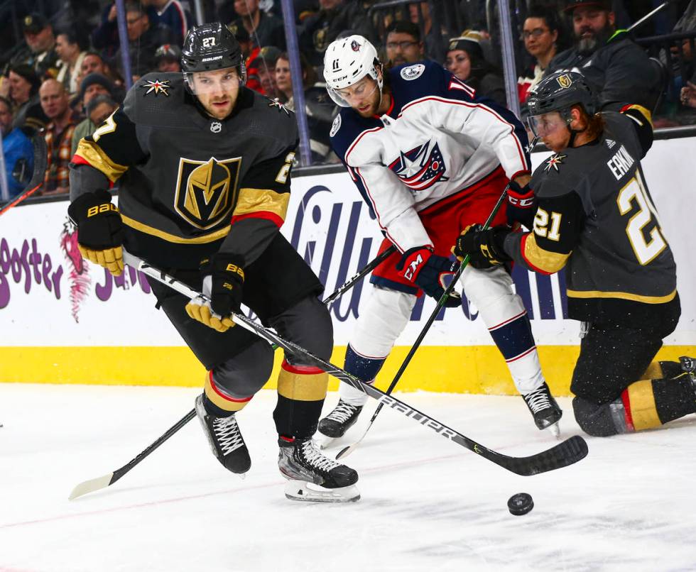 Golden Knights' Shea Theodore (27) skates with the puck past Columbus Blue Jackets' Kevin Stenl ...