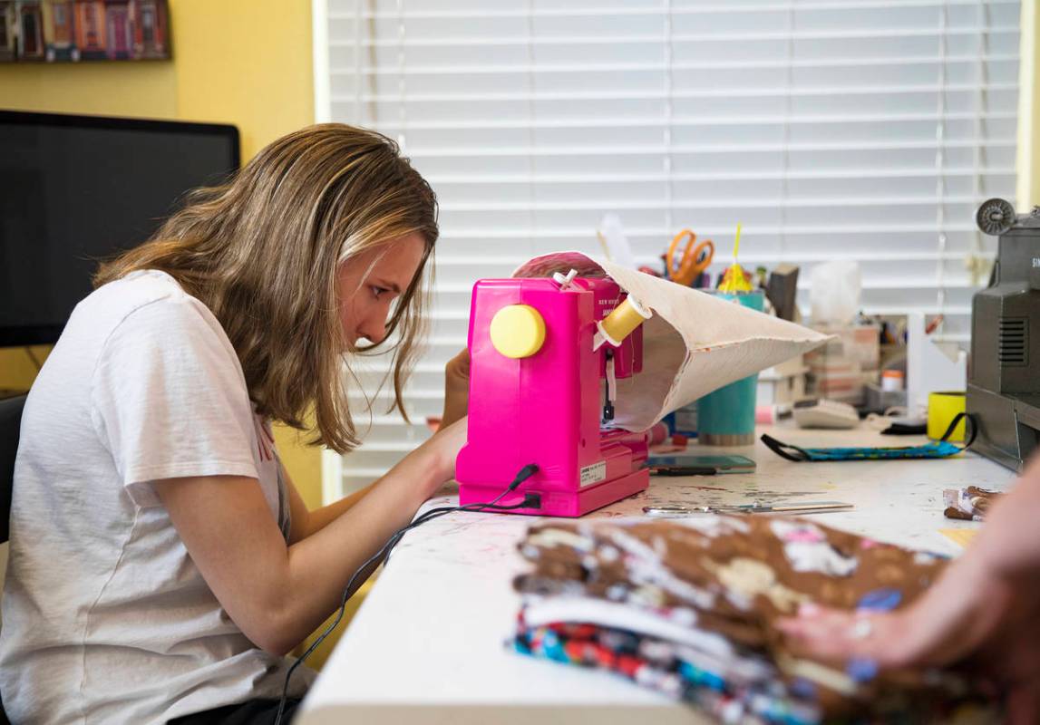 Grace Gustafson, 13, works on a mask at her home in Las Vegas, Sunday, March 22, 2020. She has ...