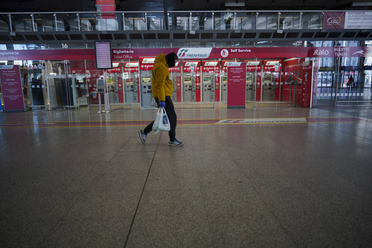 A person walks past ticket machines in an almost empty Termini main train station, in Rome, Mon ...