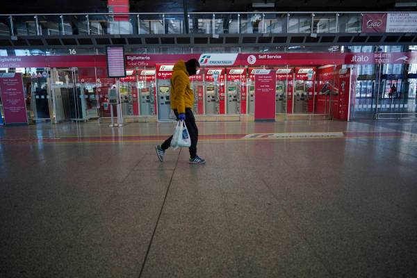 A person walks past ticket machines in an almost empty Termini main train station, in Rome, Mon ...