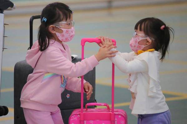 Young passengers wear face masks to protect against the coronavirus as they arrive at the Hong ...