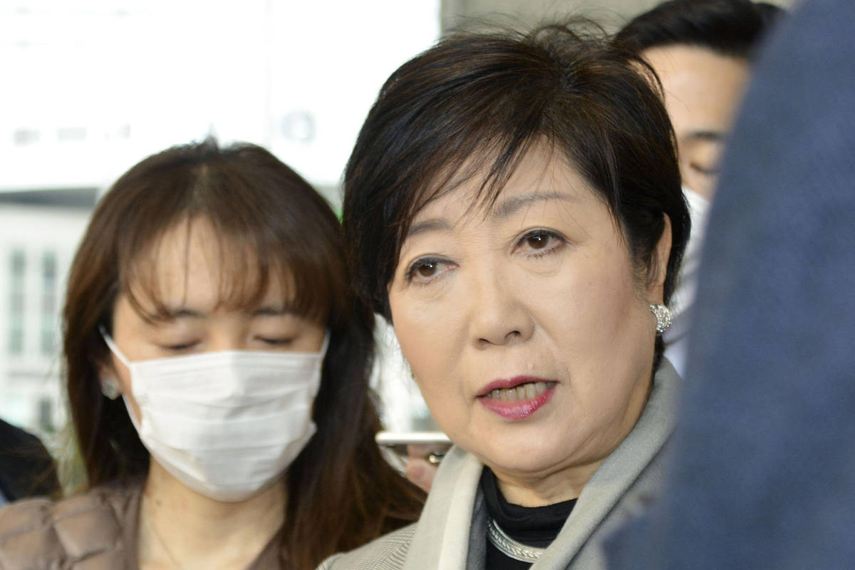 Tokyo Gov. Yuriko Koike, right, answers a reporter's question about the latest policy of Intern ...