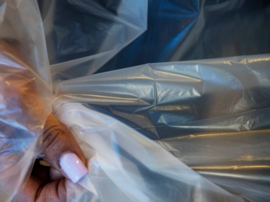 Employee Jordan Mevius shows the polyethylene material for a gown at Polar Shades in Las Vegas, ...