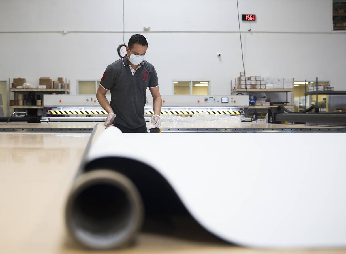 Nacho Villareal measures a roller shade to cut at Polar Shades in Las Vegas, Monday, March 23, ...