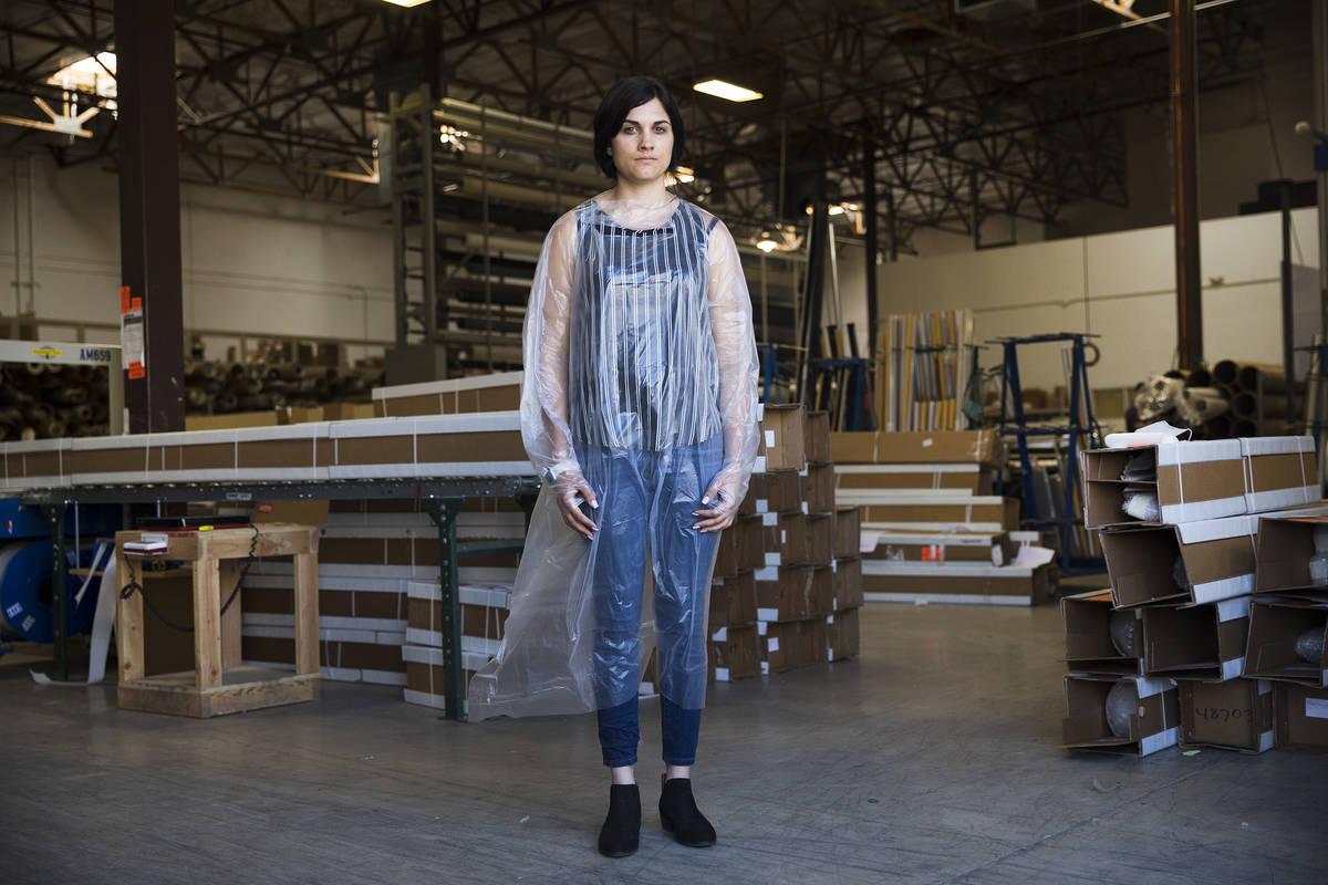 Employee Jordan Mevius wearing a gown at Polar Shades in Las Vegas, Monday, March 23, 2020. The ...