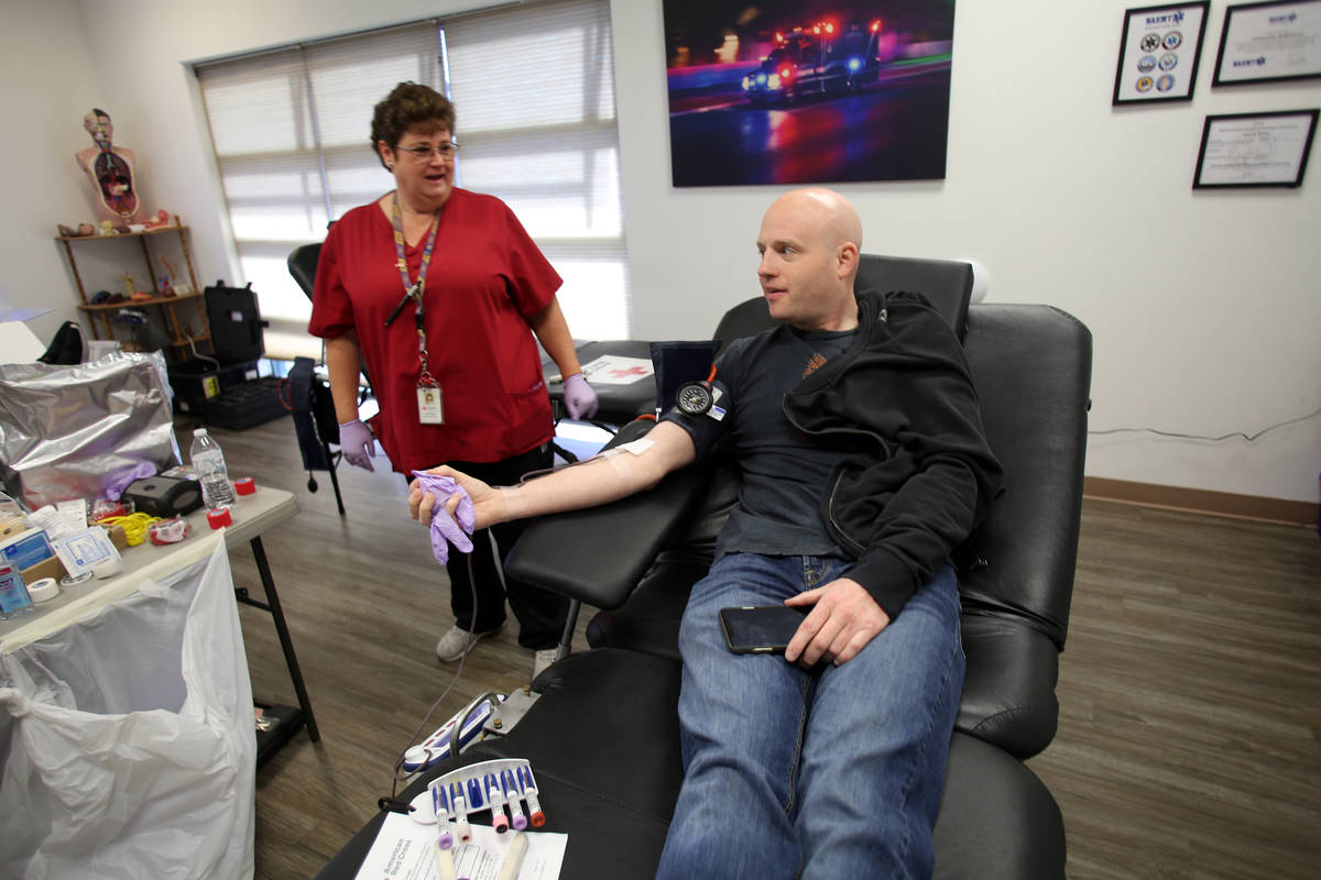 Phlebotomist Eva Clappa takes a blood donation from Matthew Daws during a blood drive sponsored ...