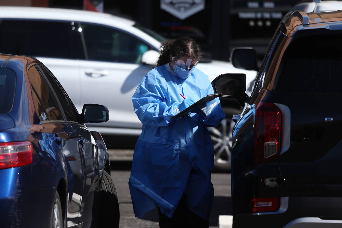 A lab technician assists people at the Sahara Urgent Care & Wellness center in Las Vegas, T ...