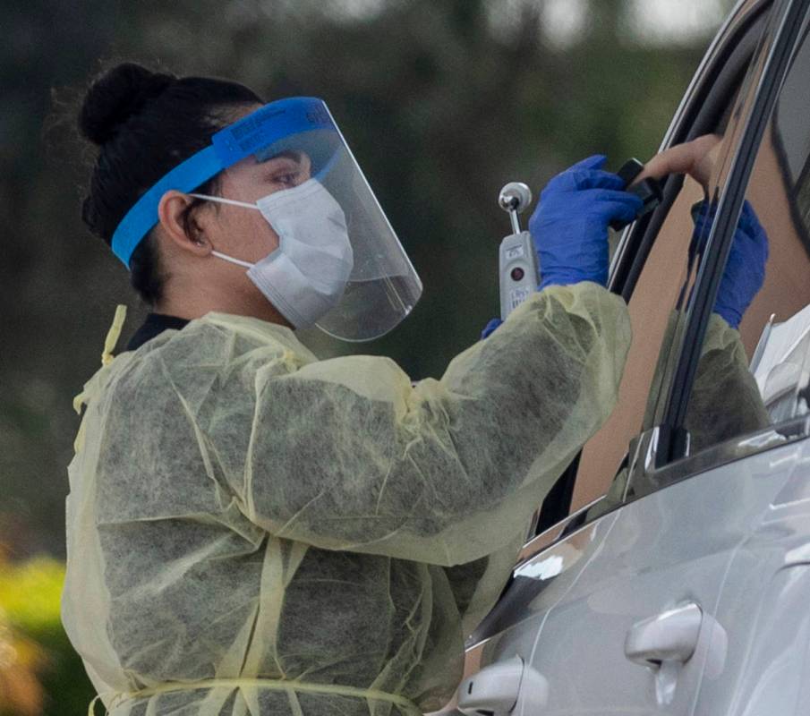 A UNLV medicine medical professional conducts a curbside test on a patient experiencing coronav ...